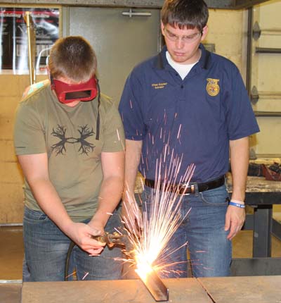 Mr. Ethan Keyser supervises a student in Basic Ag Mechanics. Photo by Macy Warren.
